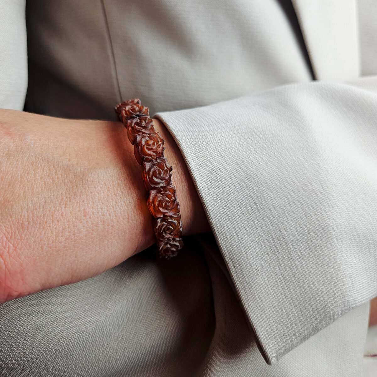 Embrace the warmth of nature and timeless romance with this exquisite honey Baltic Amber elastic bangle. Featuring dainty, hand-carved rose flowers,